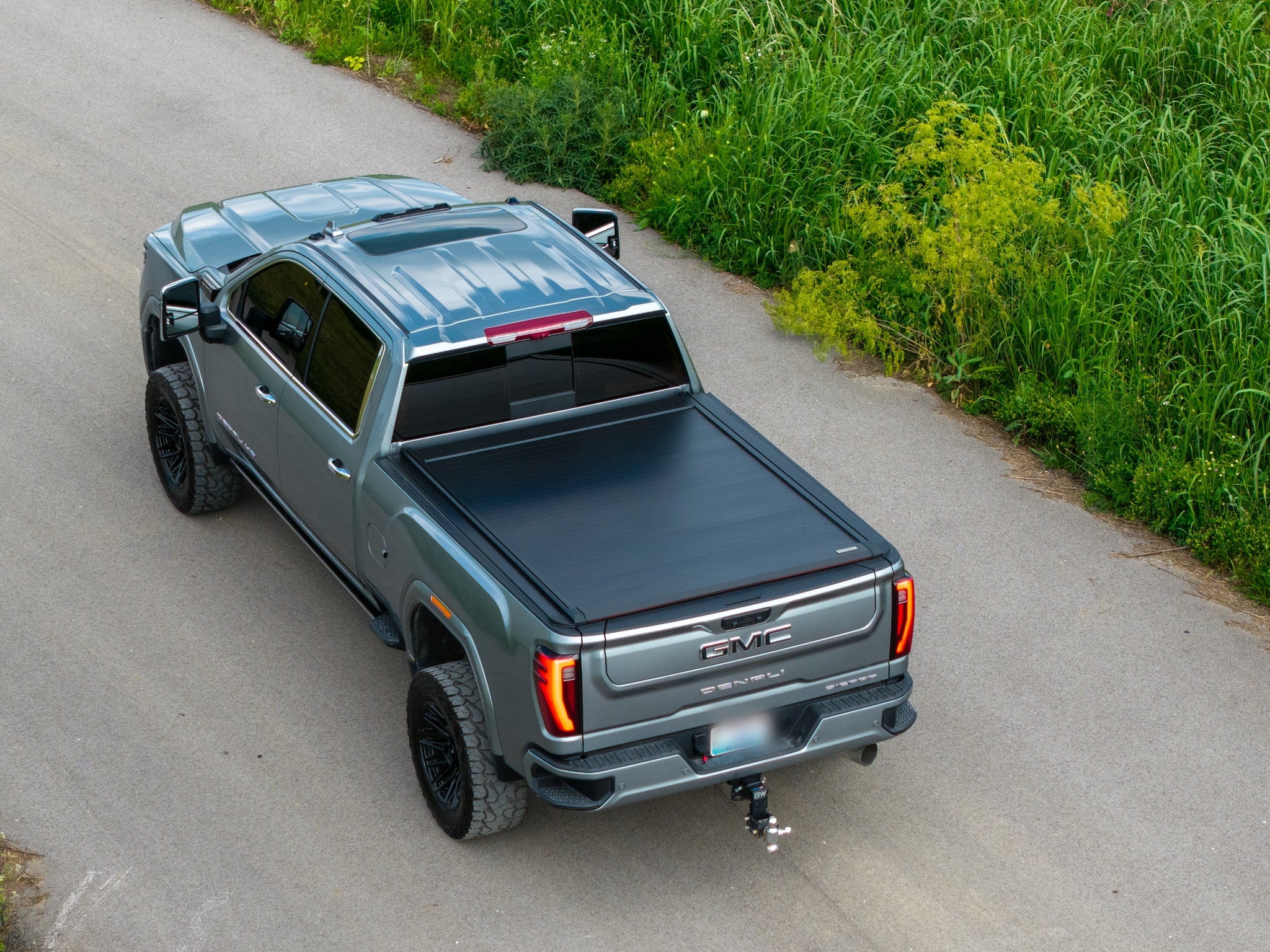 SILVEX electric retractable tonneau cover closed on a GMC Sierra Denali, aerial rear view