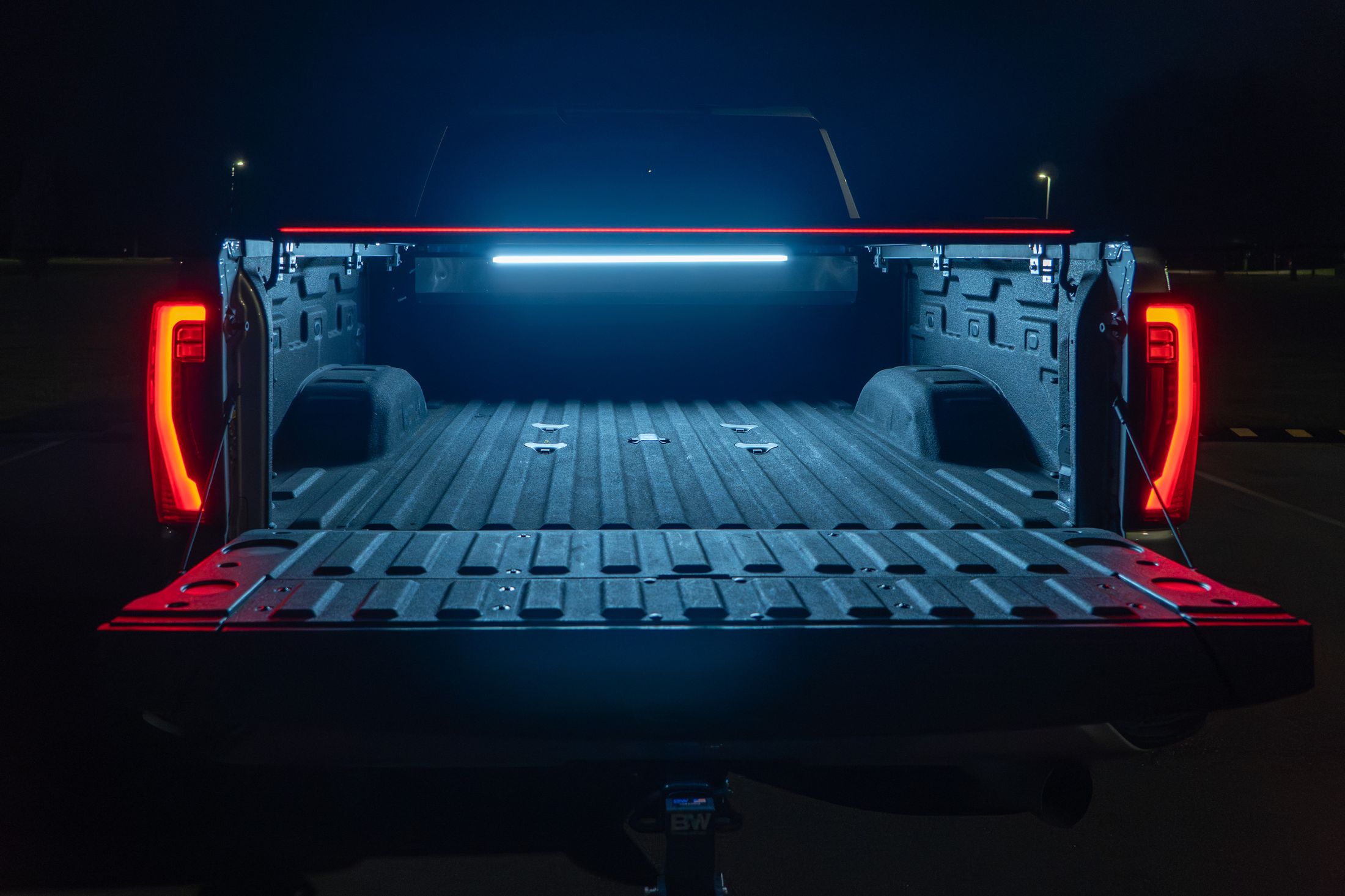 Open SILVEX cover at night with built-in LED bed lighting and glowing red light bar