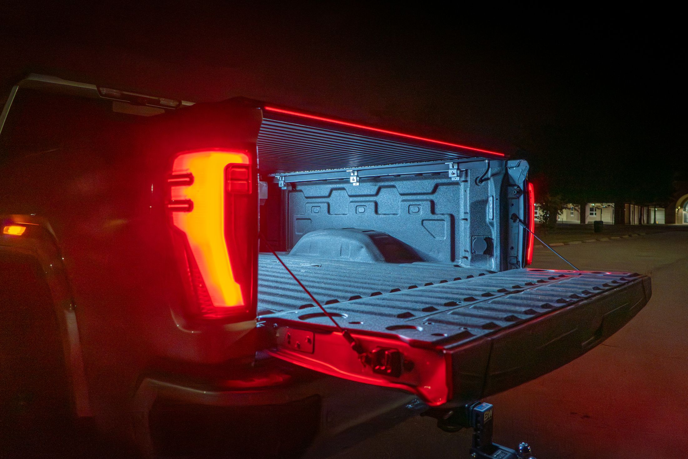 Red LED light bar glowing across the tailgate at night